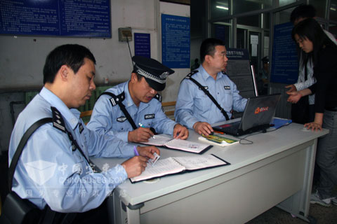 派出所民警为进站乘客登记身份证